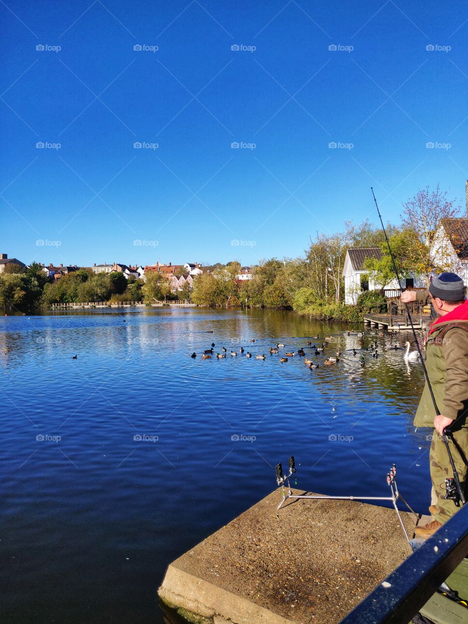 Man fishing in town mere