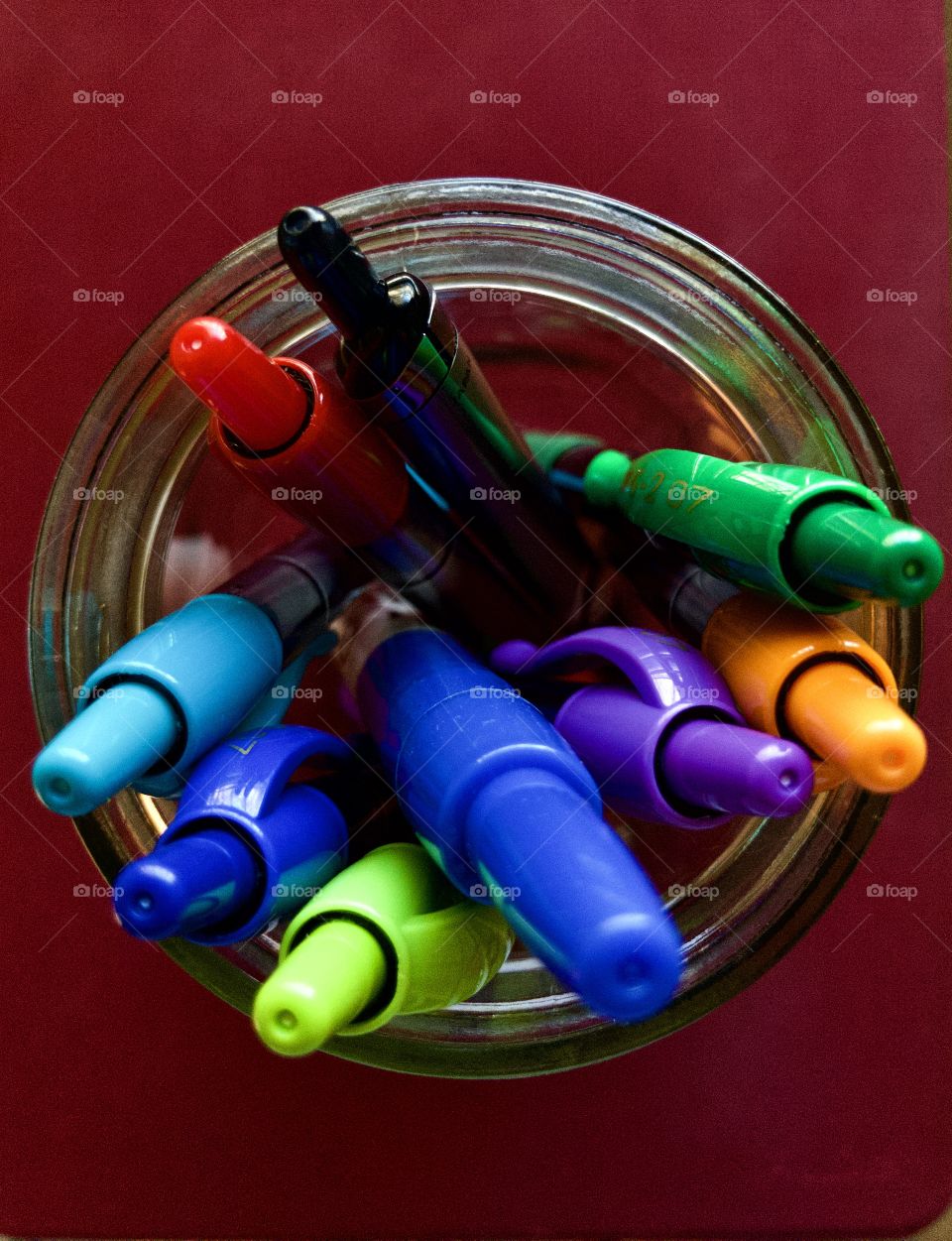 Colorful pens in glass jar