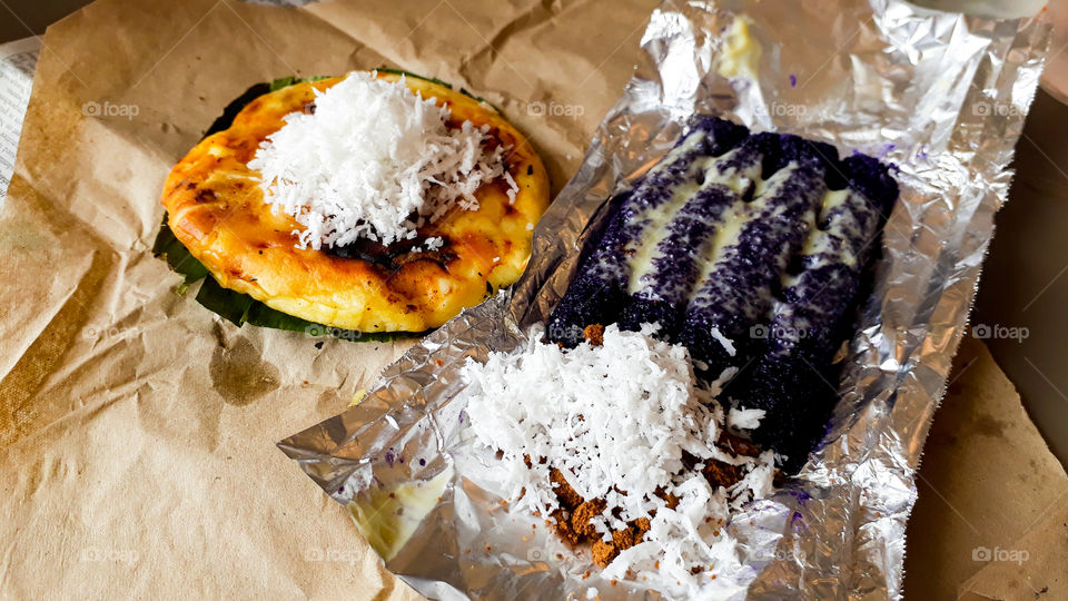 This Filipino Delicacies is traditionally served during Christmas season. Bibingka (left) a filipino hotcake with salted eggs and shredded coconut on top and Puto Bumbong (right) a steamed glutinous rice that is cooked inside a bamboo with condensed milk on top and shredded coconut with coconut sugar on the side.