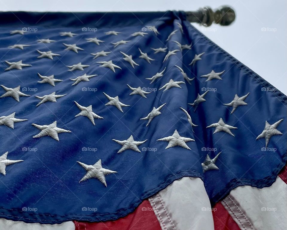 The American flag with its 50 embroidered white stats hangs outside a home in Washington State 