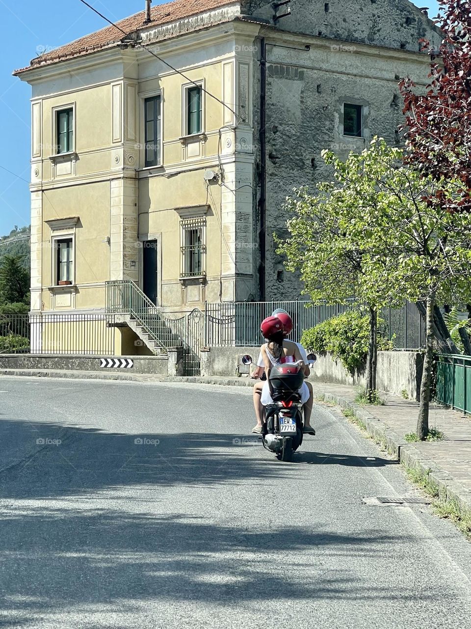 Couple riding scooter in Italy