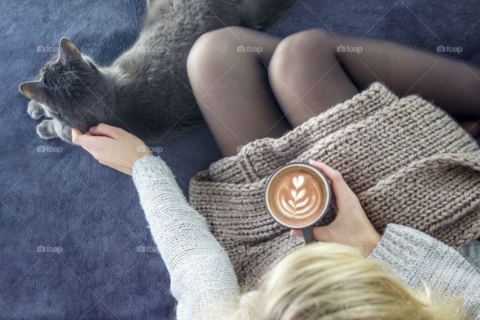 Girl with a cup of coffee and cat