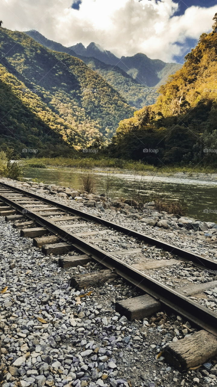 Train tracks make every picture better. The perfect scene in the middle of the Inca Jungle, trekking to Machu Picchu. The rail road cuts right through the forest along the river to show the beautiful Peruvian landscape.