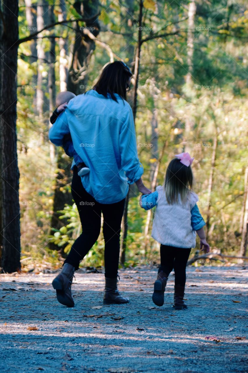 Woman with two children's walking in forest