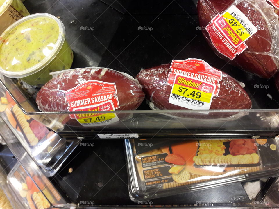 Summer sausage that is shaped like a football for the Super bowl. The meat aisle of the grocery store.