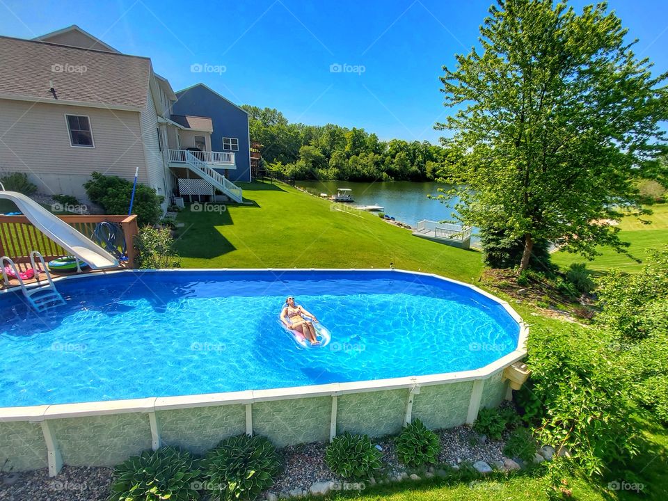 woman sunbathing in backyard pool