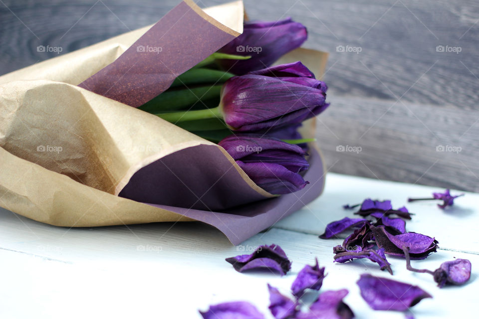 A bouquet of tulips and purple rose petals