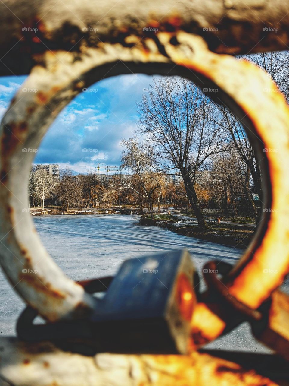 Round part of the old iron bridge over the river in the park. Winter landscape