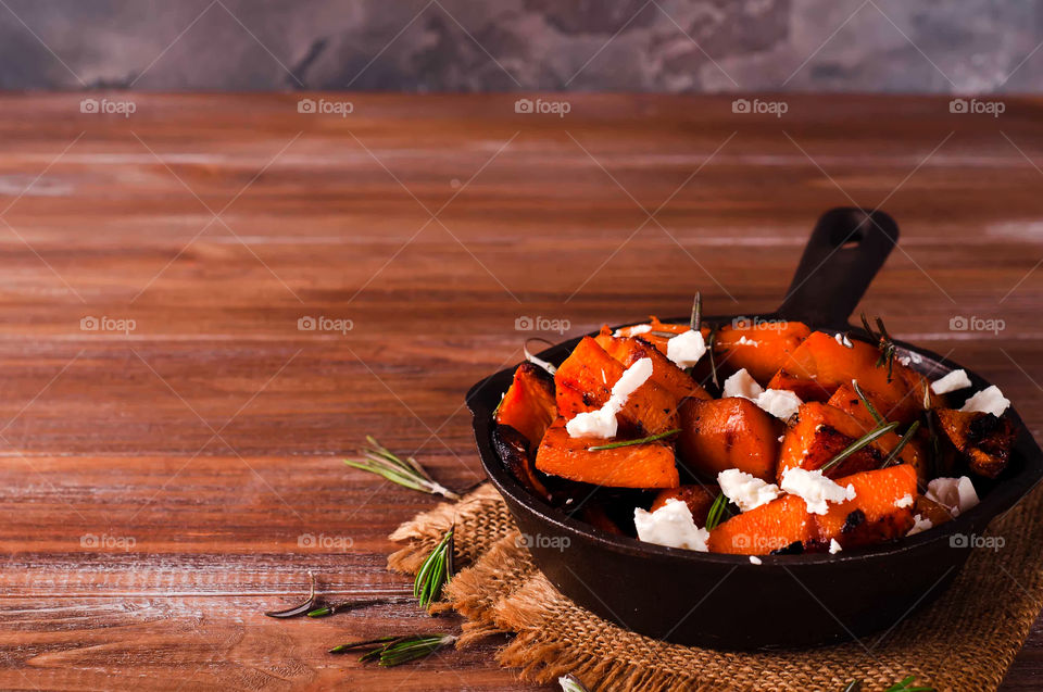 Healthy pumpkin with cheese in pan on table