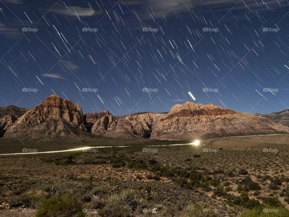 Beautiful Red Rock Canyon illuminated by the lights of Las Vegas and a full moon.