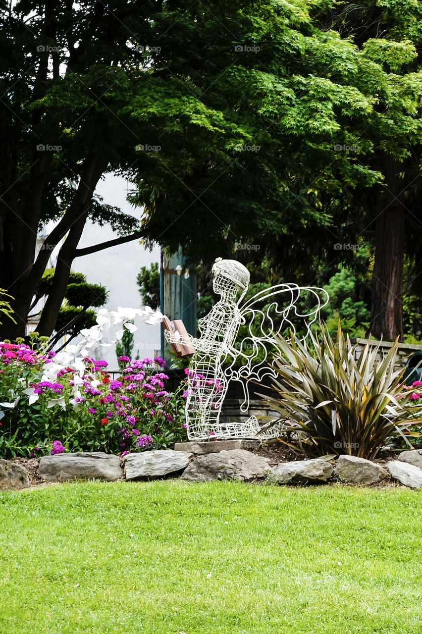 A fairy reads butterfly stories to the plants in the garden