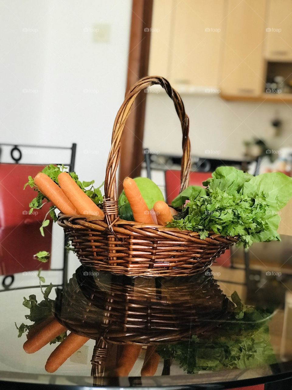 A basket full of fresh vegetables on the dining table.