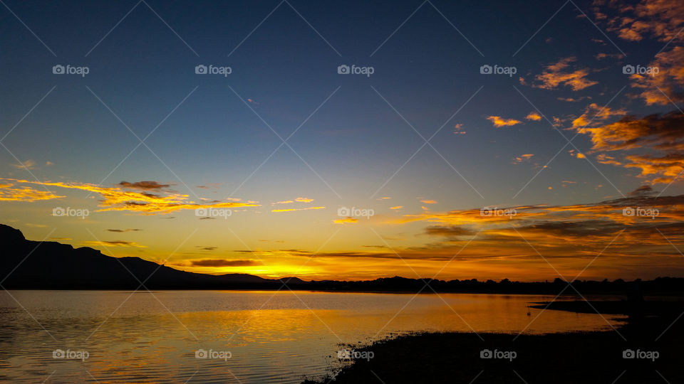 sunset over a lake with some cloud cover