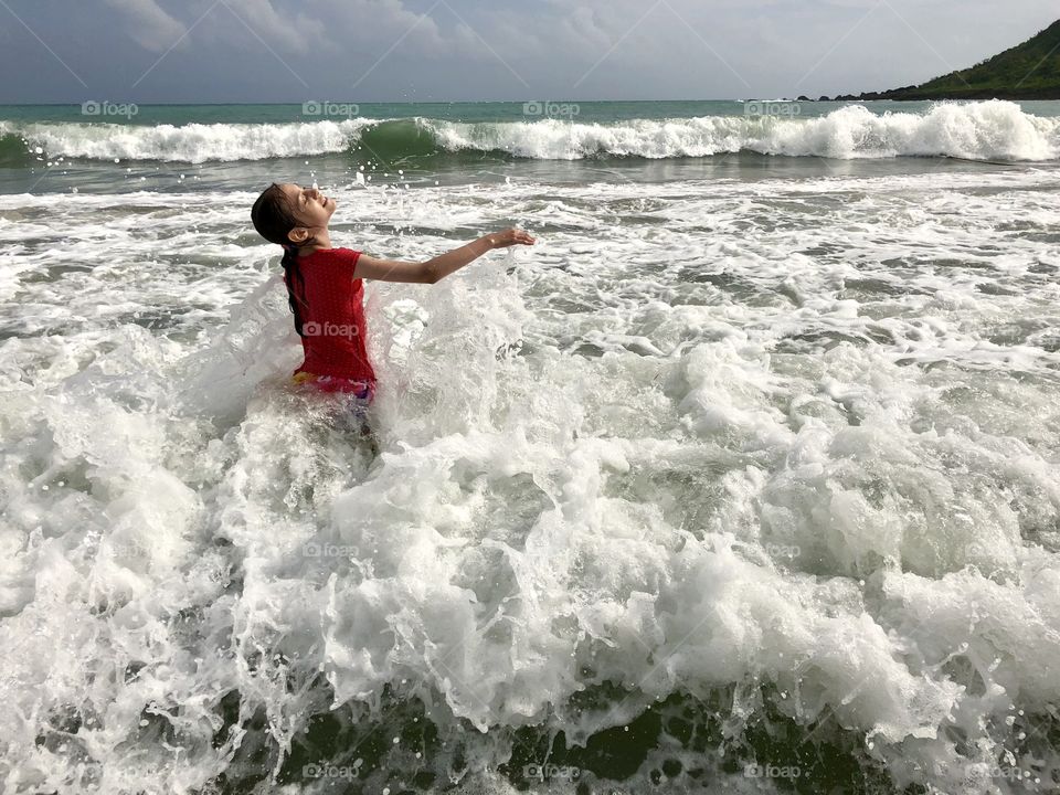 The child splashes into the sea