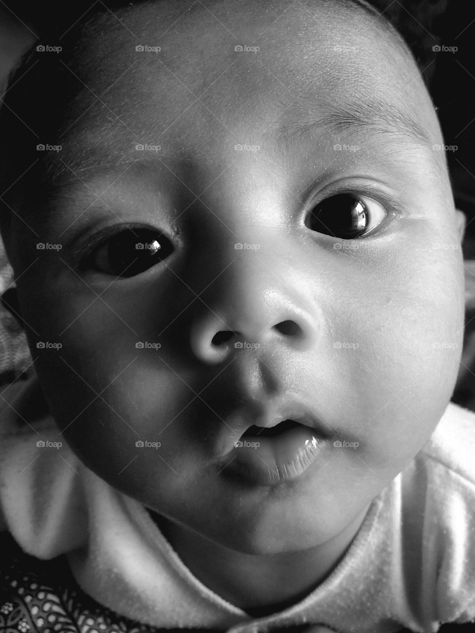 facial expression of a baby boy looking at the camera when photographed up close.