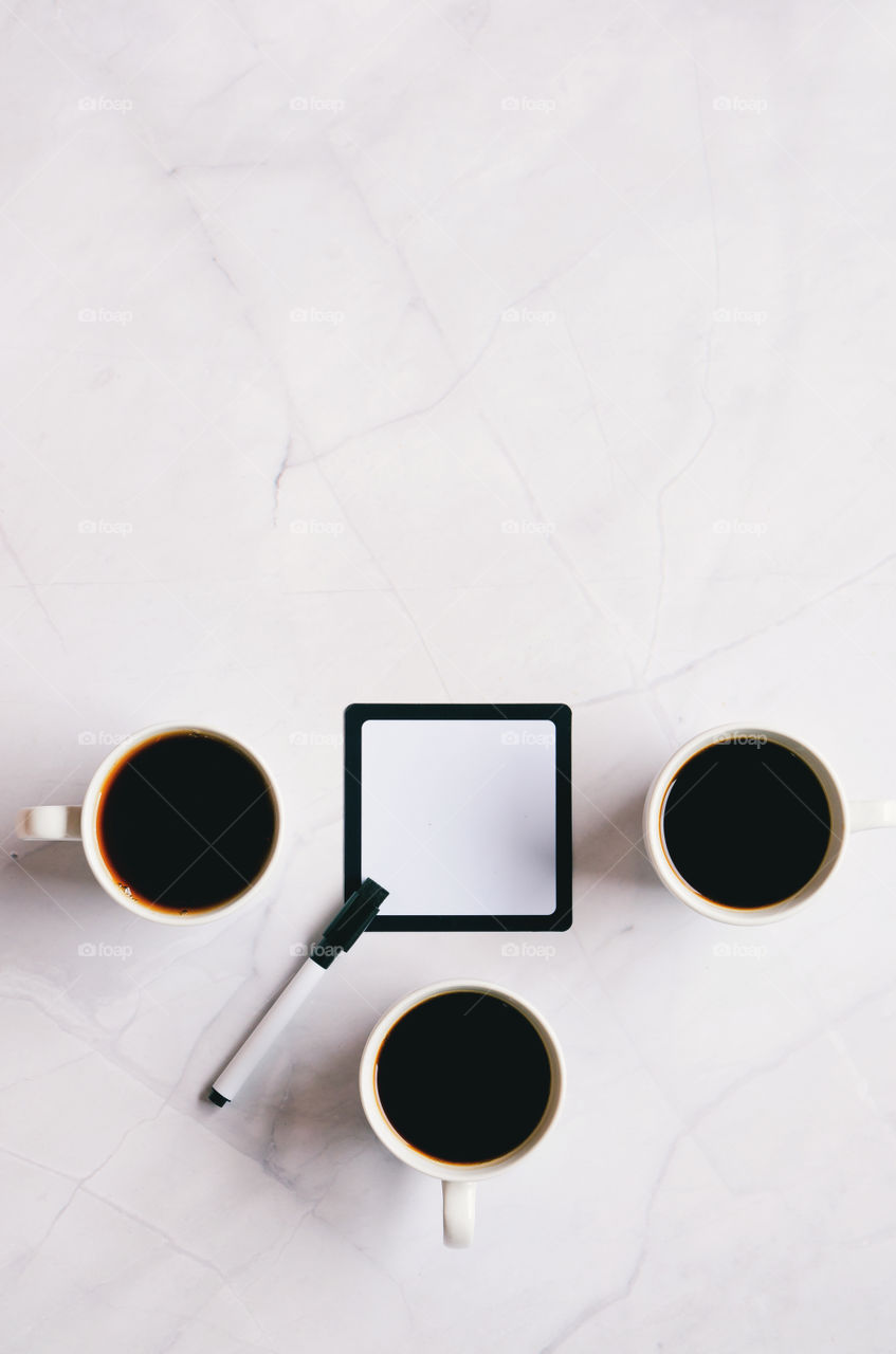 Business working morning with cup of hot coffee, sweet croissants, pen, notebook on white background close up. Top view, copy space, flat lay, mockup.