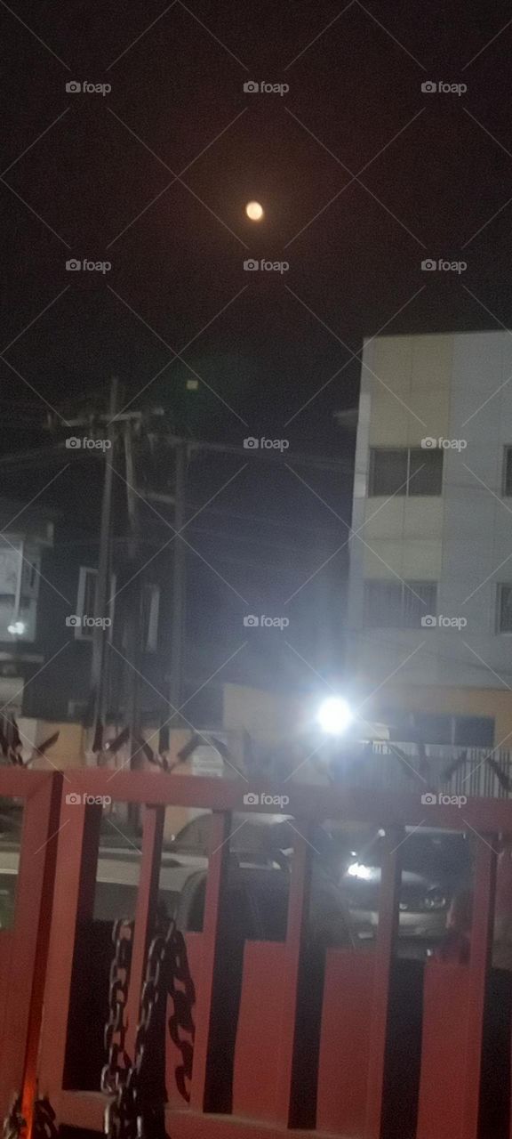 Moon visible over houses