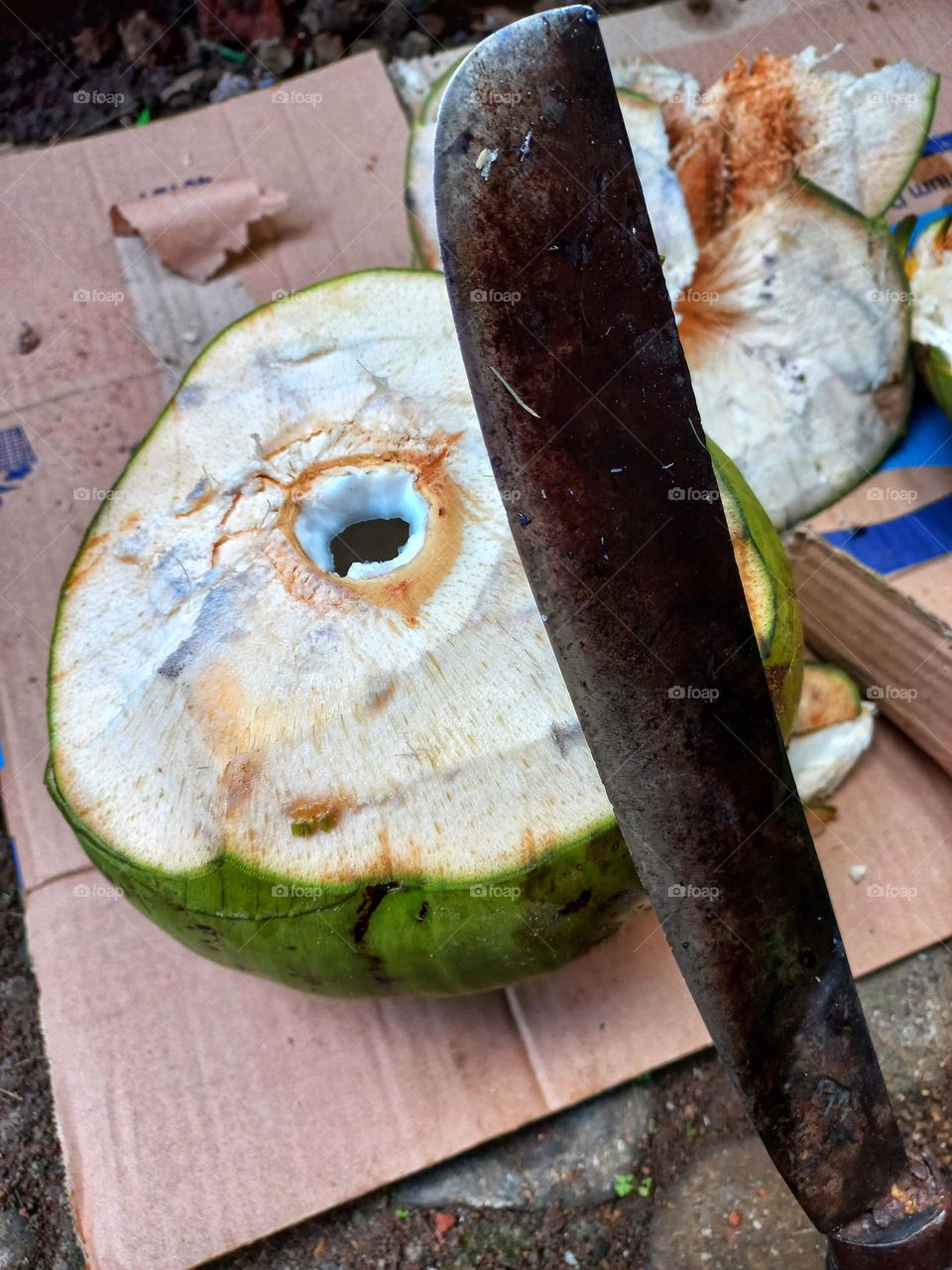 Green coconut is being peeled or water is being taken out