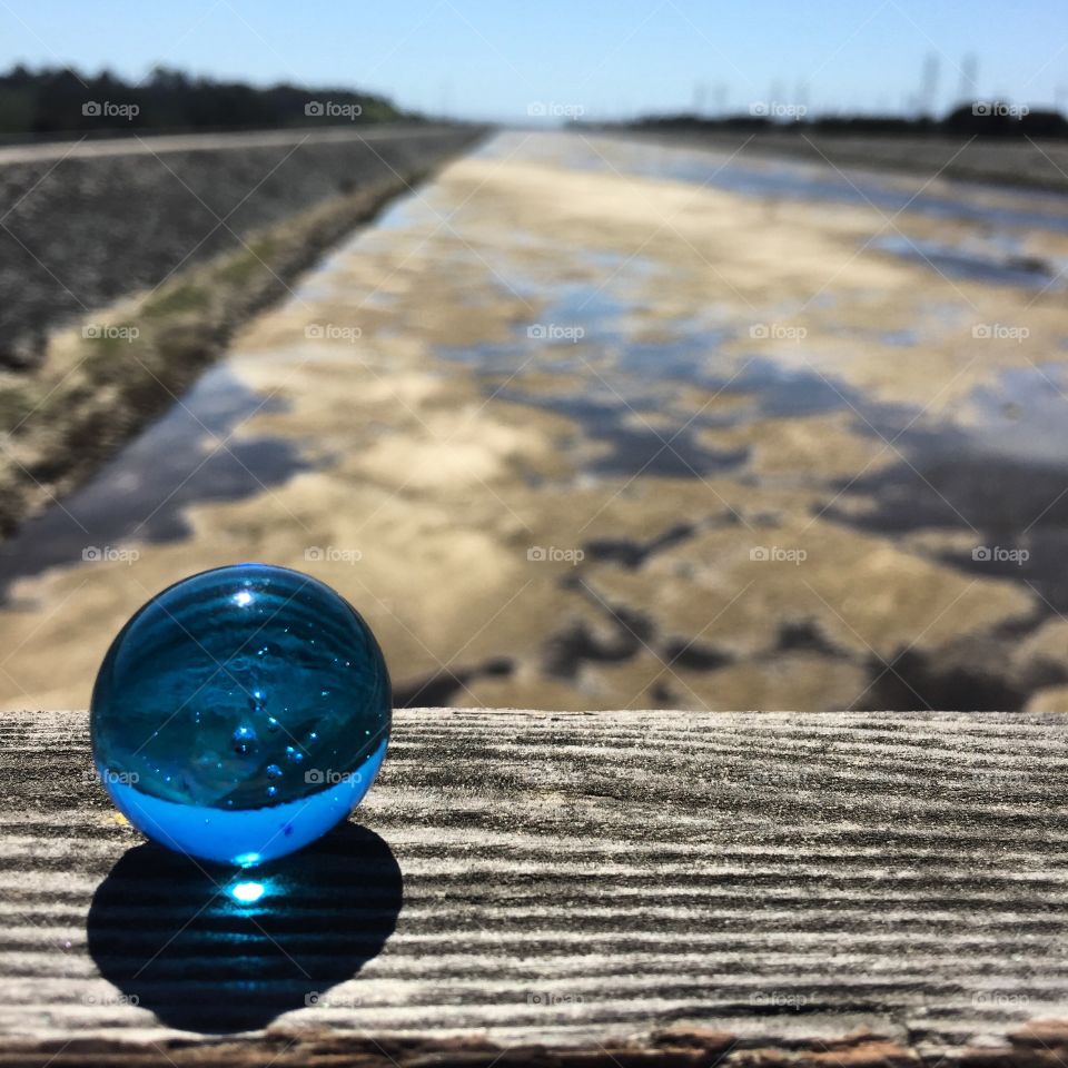 Our water-blue planet against a dry riverbed 