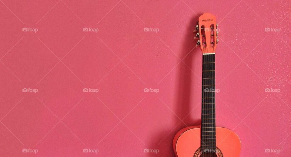 guitare in the pink. minimalism photo of a guitar with a pink background 