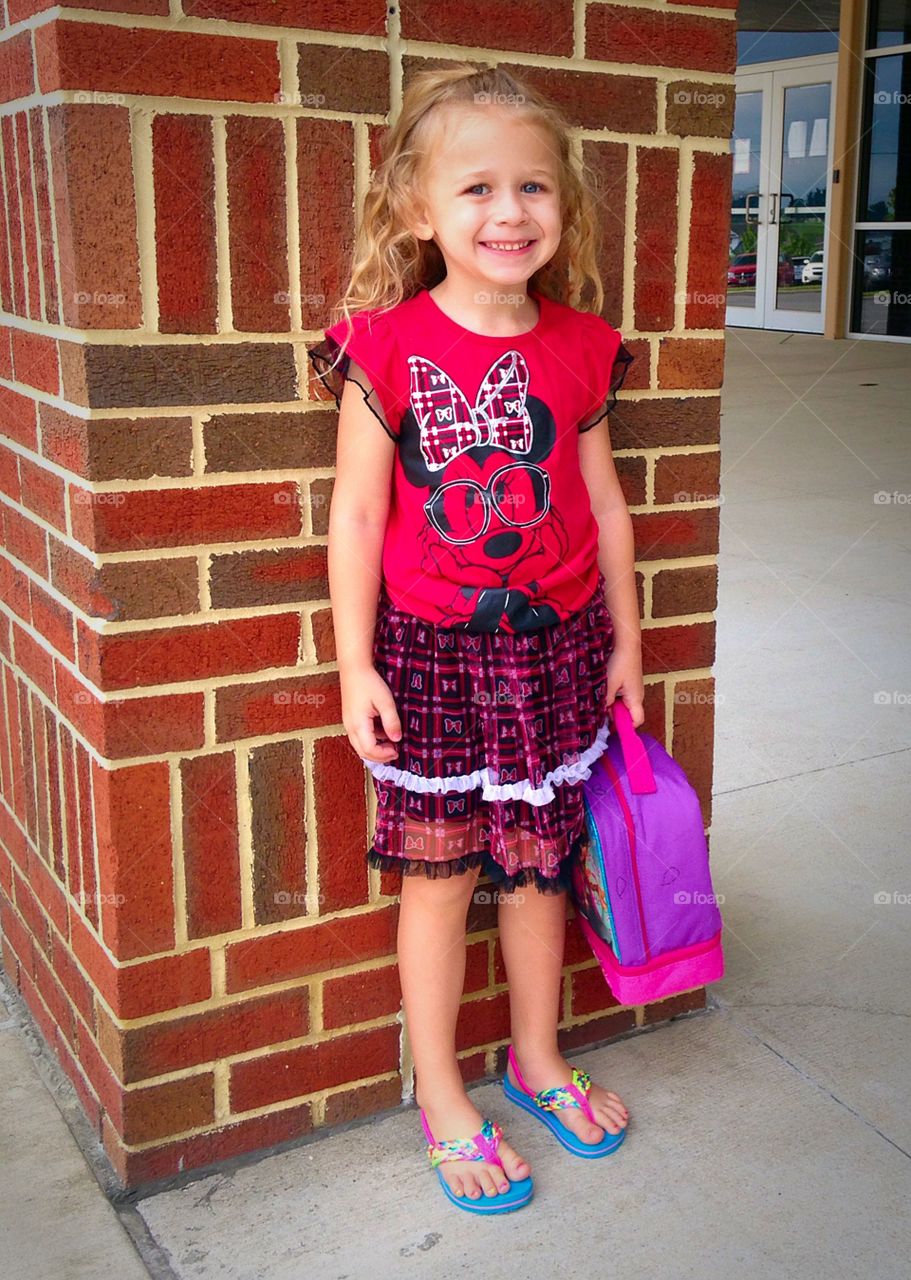 Smiling girl standing with holding bag pack