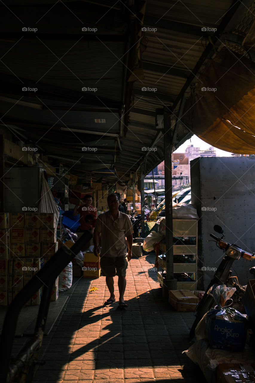 Man walking along the market corridor during the day