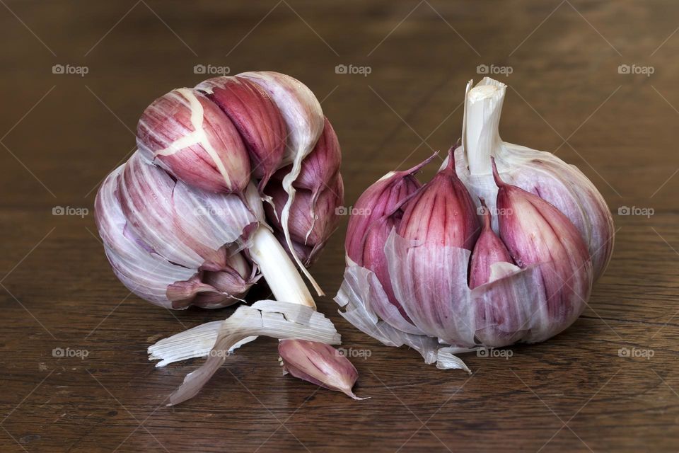 Organic freshly harvested garlic bulbs on wooden background, closeup