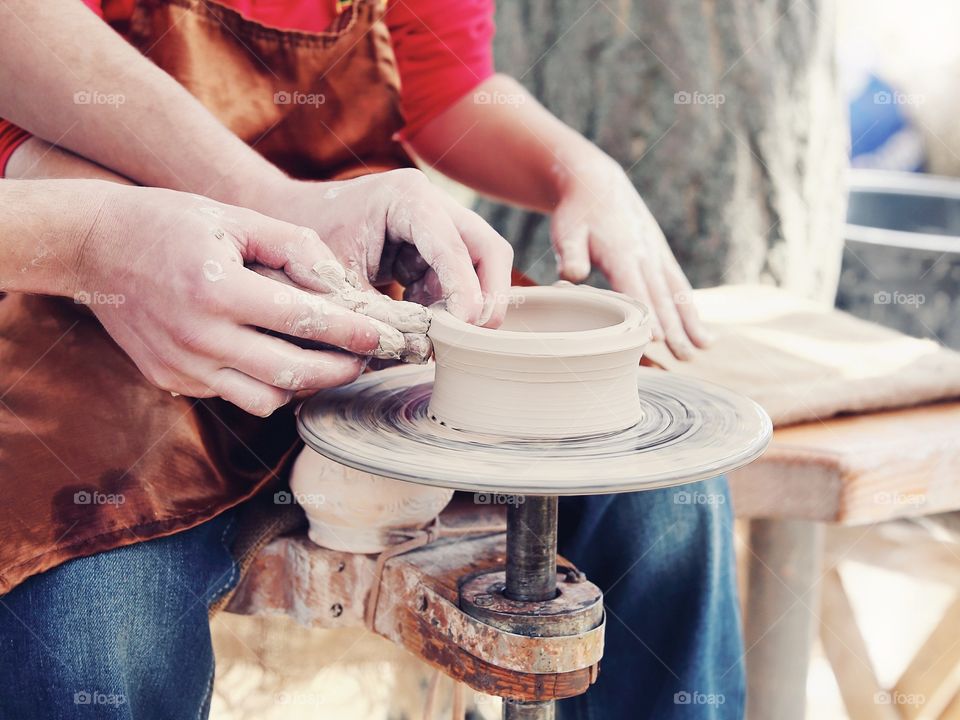 Man and child hands doing clay pottery