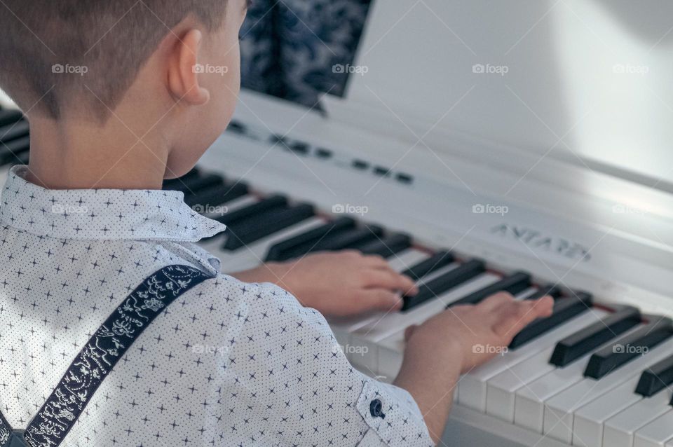 The boy plays the piano.