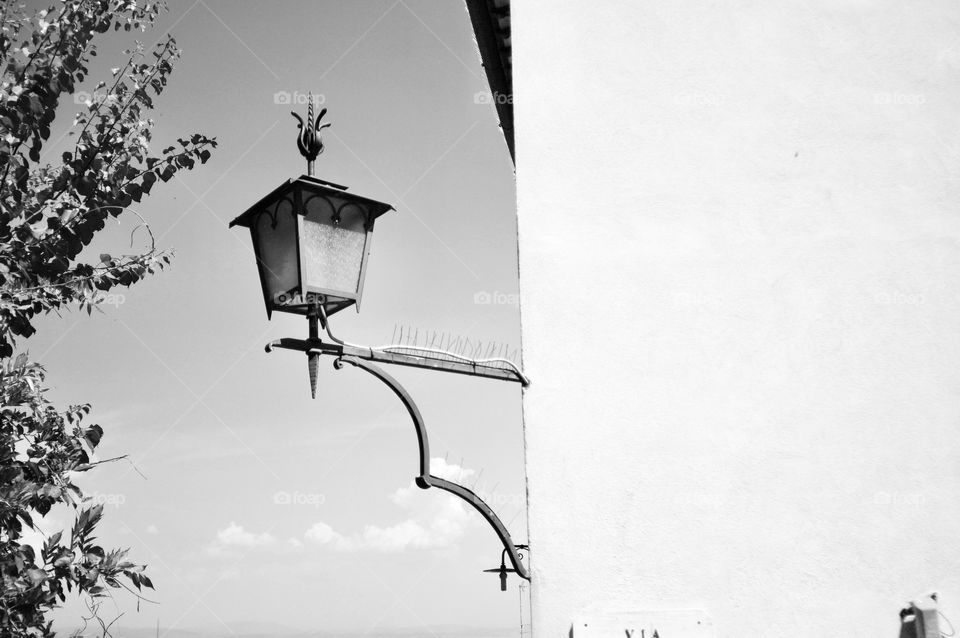 A beautiful street lamp hanging from the side of an house in Siena, Tuscany 
