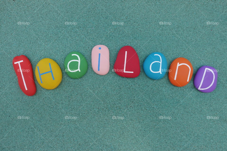 Thailand, Kingdom of Thailand country at the centre of the Southeast Asian Indochinese peninsula, souvenir with colored stones over green sand