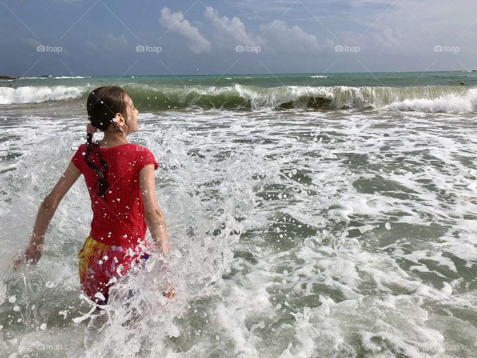 The child splashes into the sea