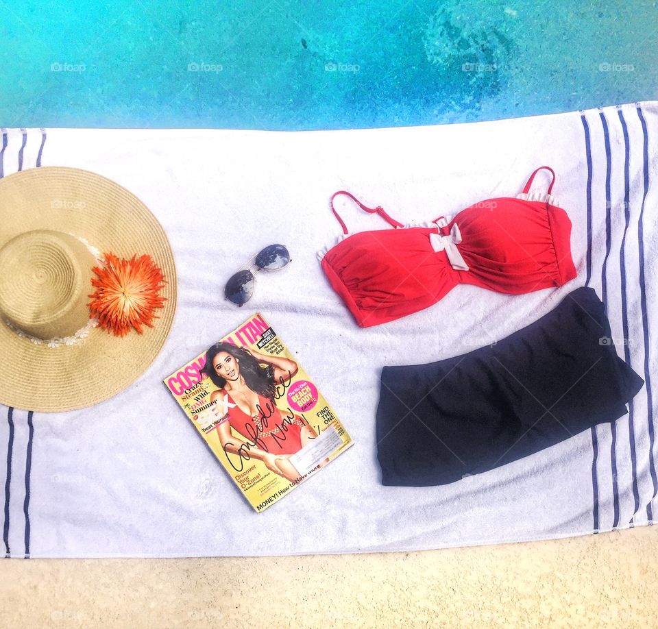 A towel, a magazine, sunglasses and a summer hat!