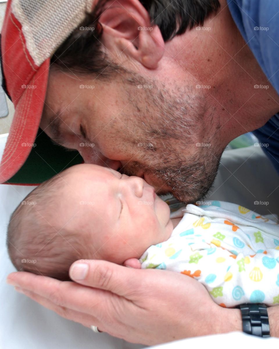 Father kisses his newborn son
