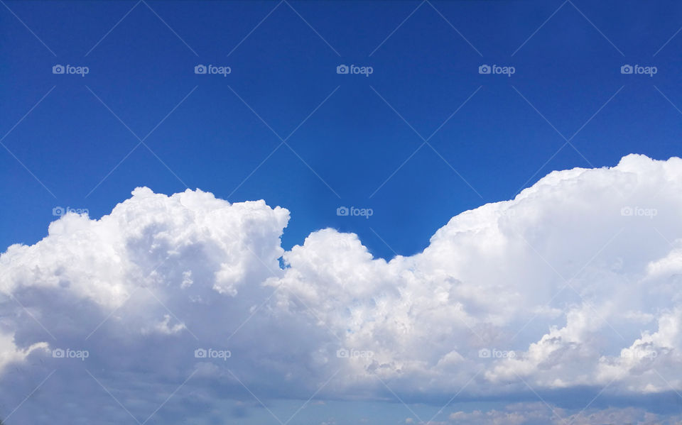 Beautiful white clouds against blue sky with sunshine for background with copy space.