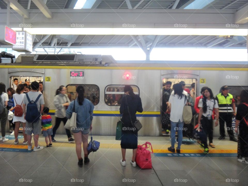 Overcrowded trains during commuting hours.The train is entering the station.Passengers getting on and off