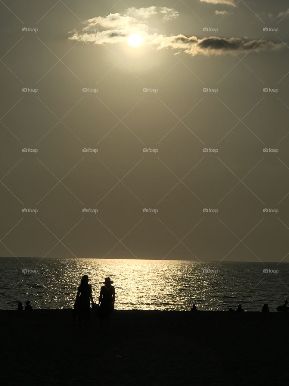 Two women on the beach in silhouette at Dusk just before sunset on the Gulf coast of Florida 