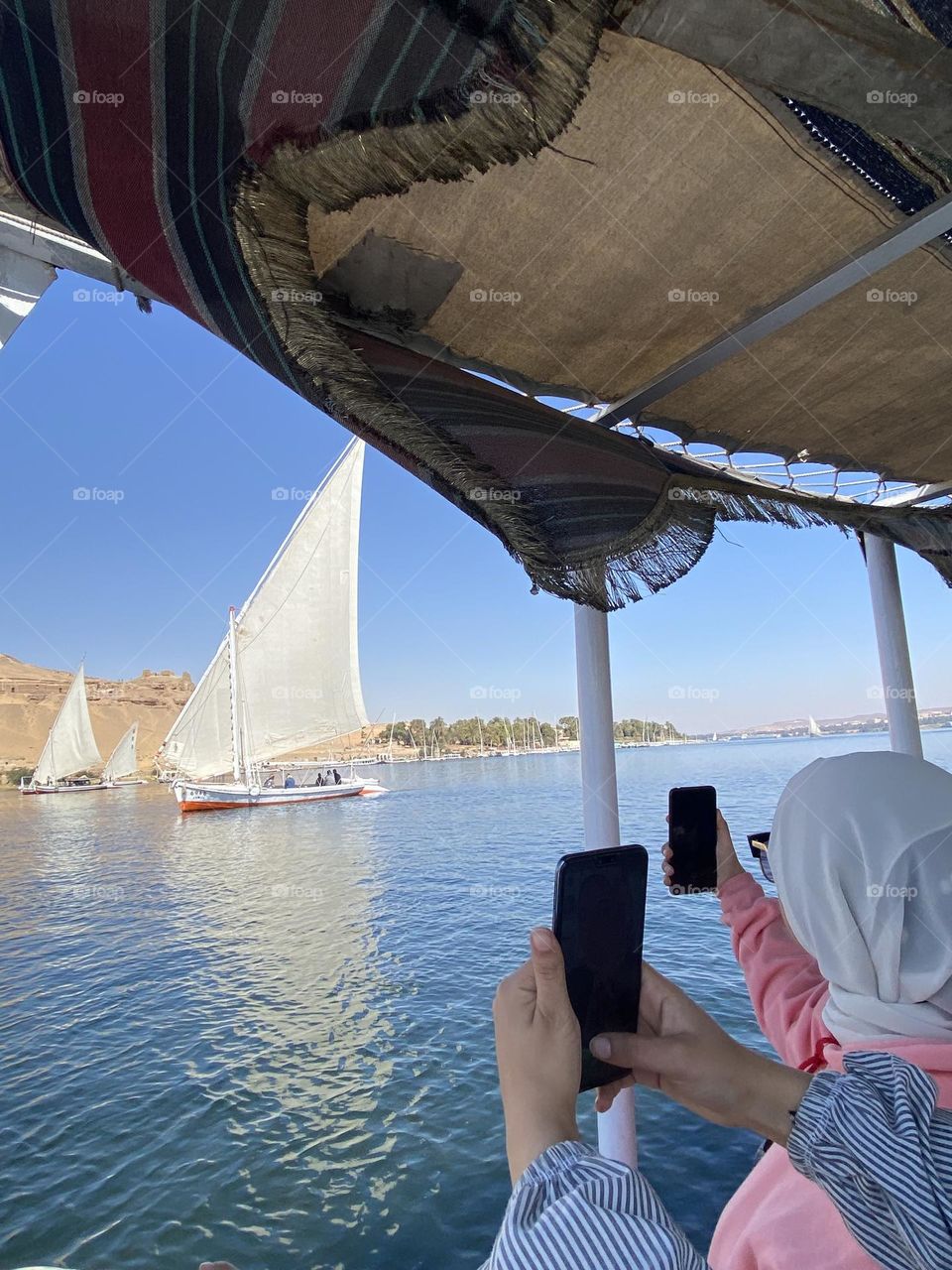Girls are using their phones to capture a beautiful view