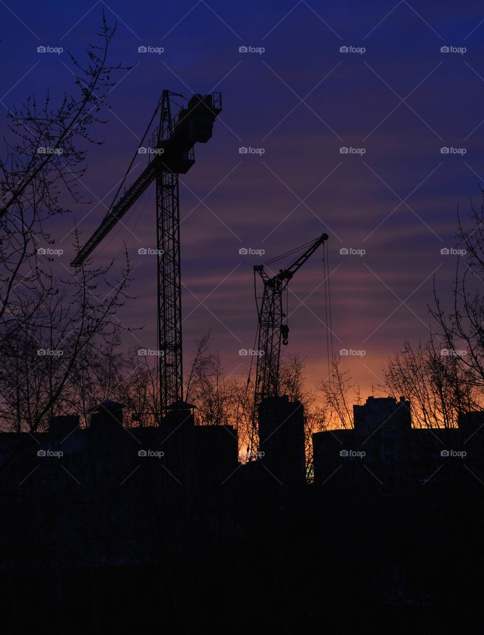 building cranes and houses roofs beautiful colour sunset sky background