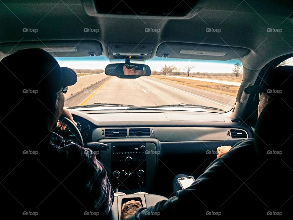 Two men driving down the road