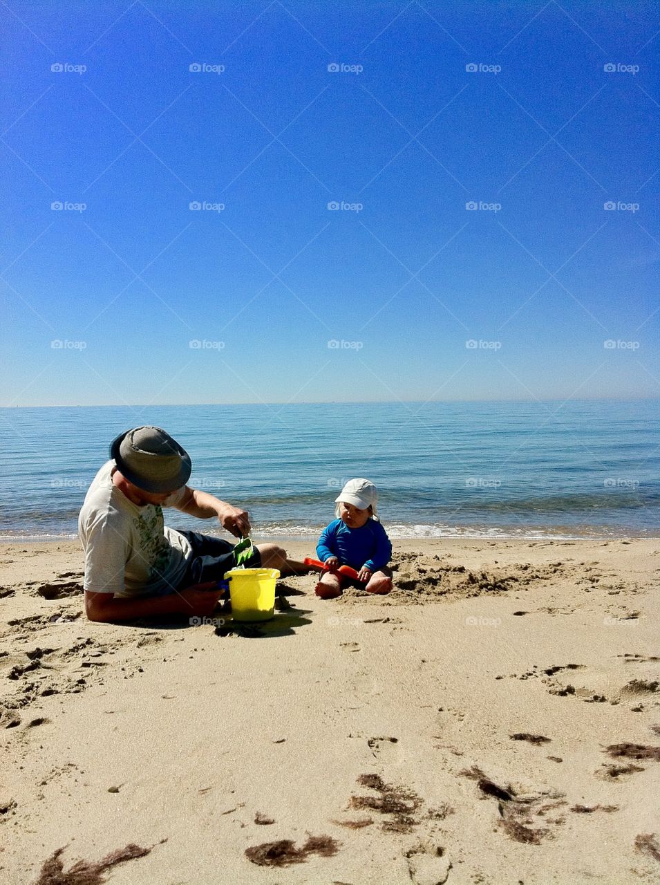 Dad and toddler playing at the beach, Sweden 