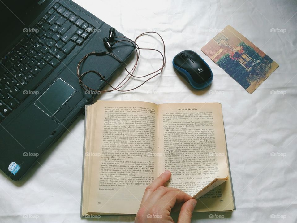 Laptop, book, headphones, computer mouse on the table