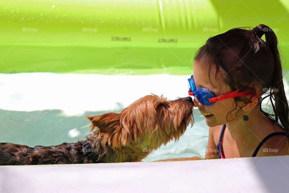 Child and her best friend in a blowup pool