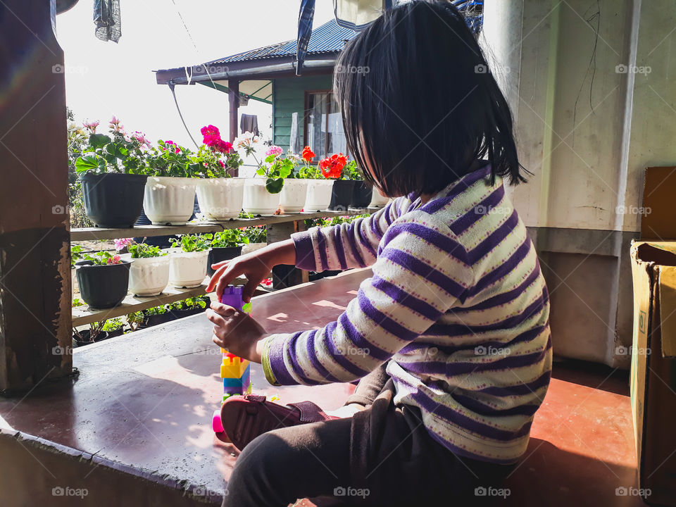 A little girl playing with blocks, enhancing her creativity