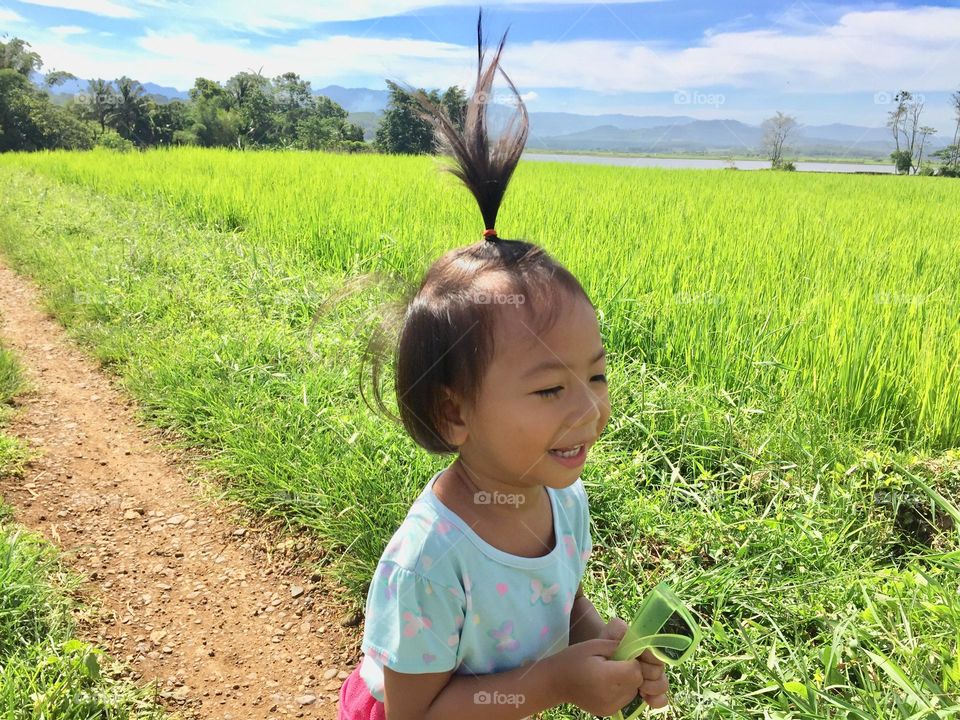 Little girl enjoying the life in the green-fields