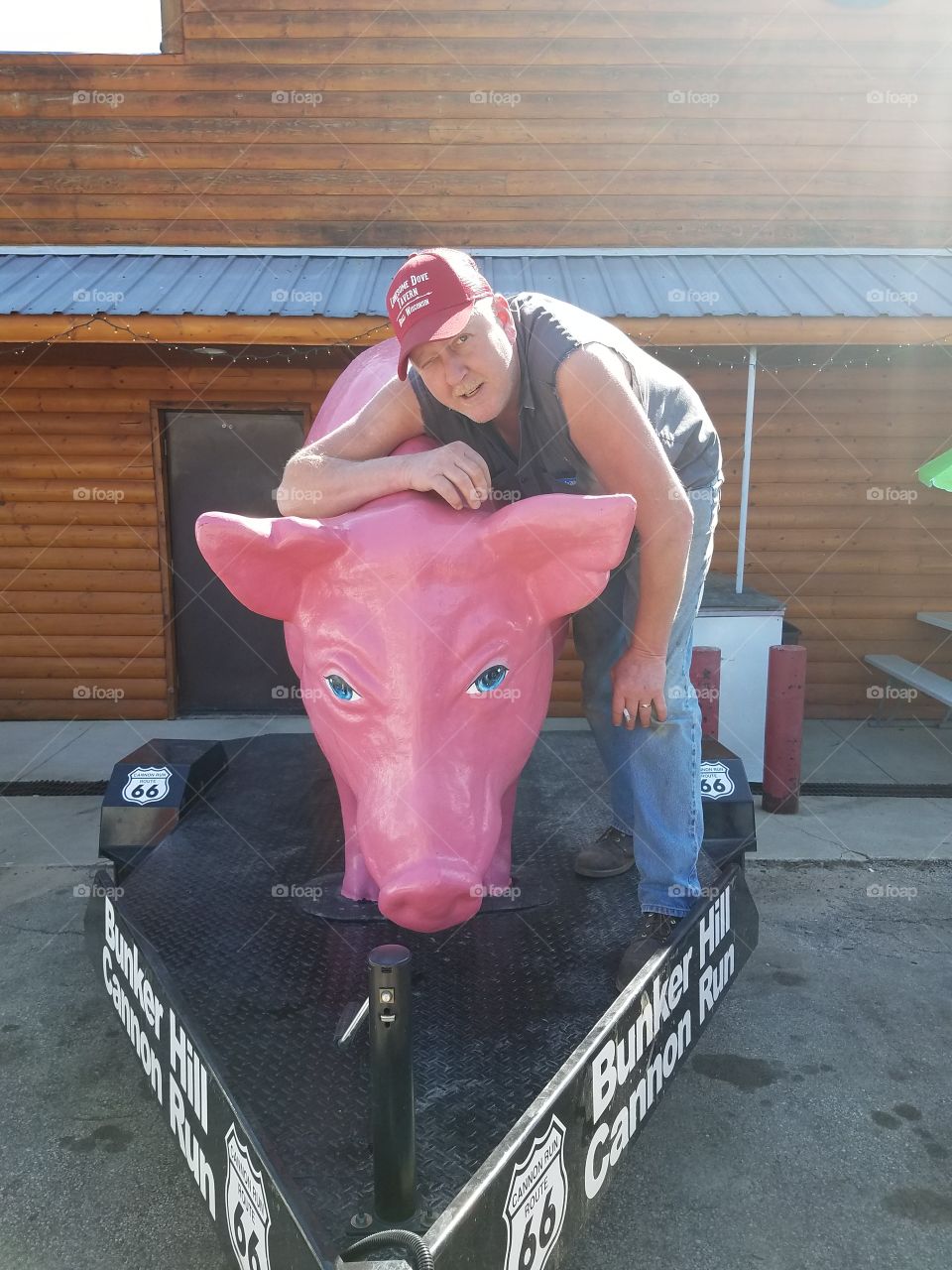 Mature man standing near statue of pig