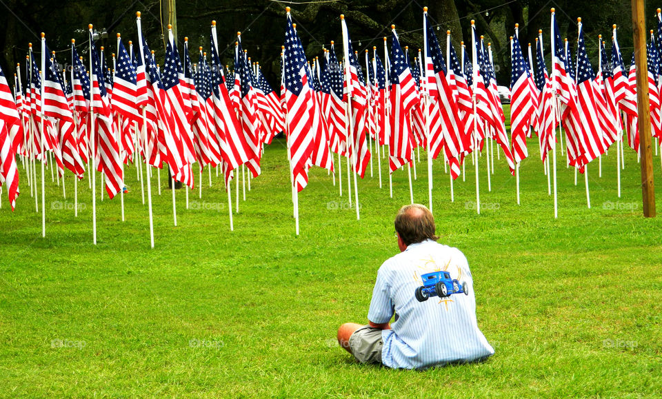 Somber Moments. A father of a service member killed in action, grieves as he overlooks 352 American flags that represent service members