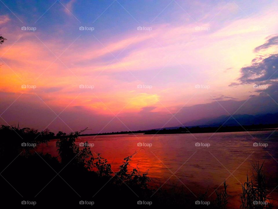 Amazing sunset reflection on the subansri river water in evening time in the India