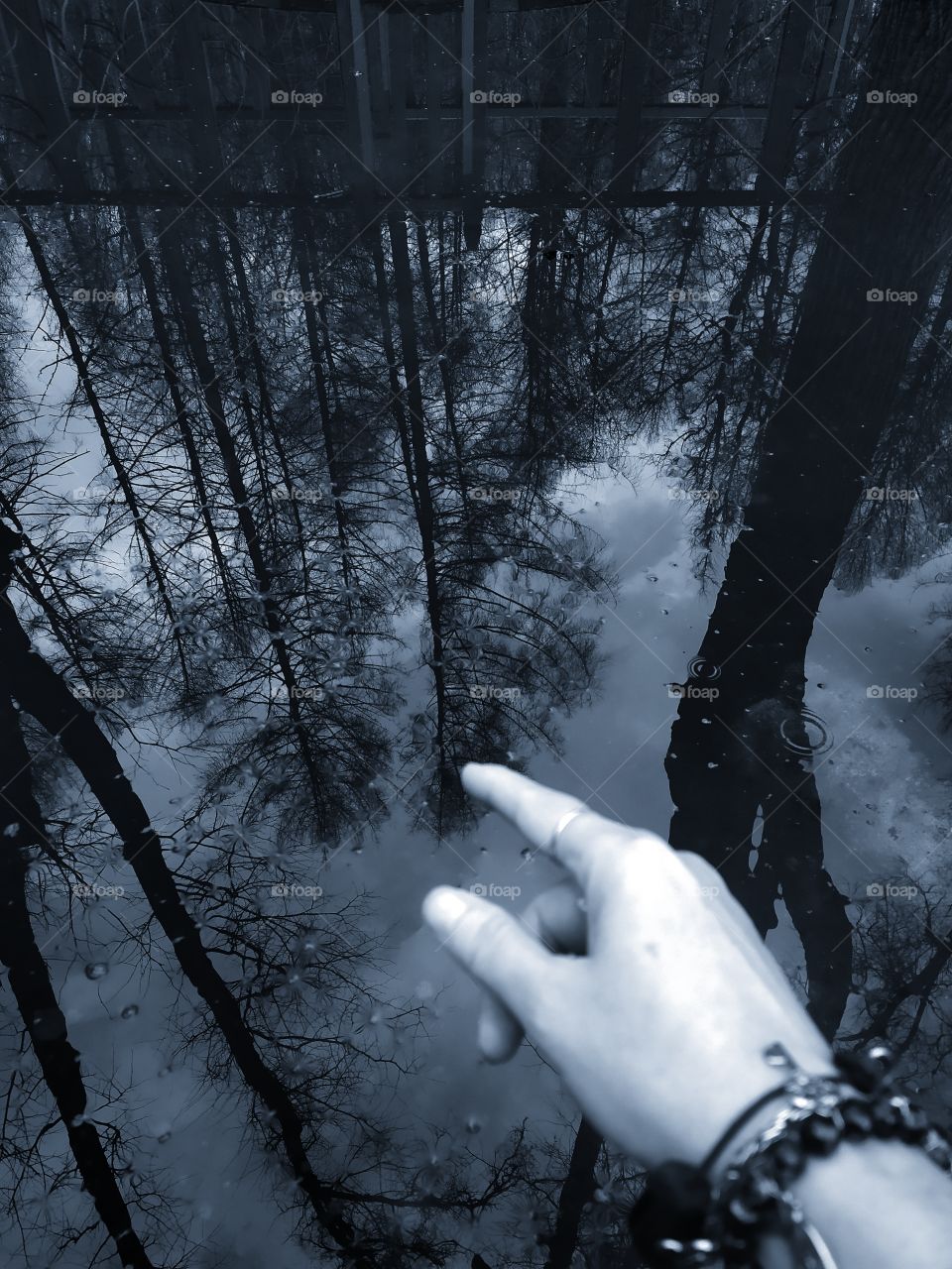 Touch the sky.  Woman's hand touch the reflection in the water
