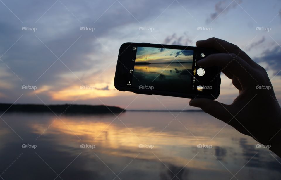 Silhouette of person photographing beach